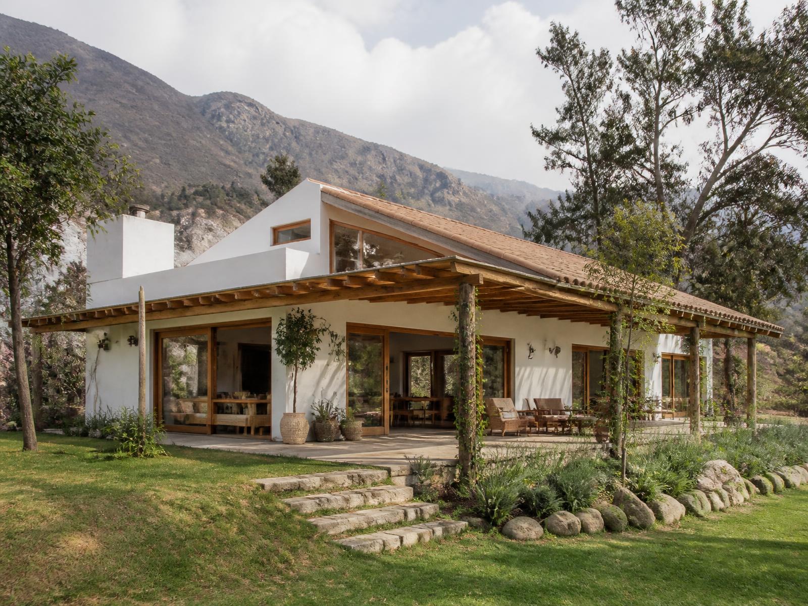 Casa de campo de muros blancos y madera con terraza abierta al jardín en Casa Huerto Doña Luz